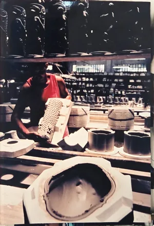 Artesão manuseando um molde de gesso no atelier de moldes da fábrica